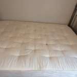 A professional cleaning a mattress with equipment in Essex.