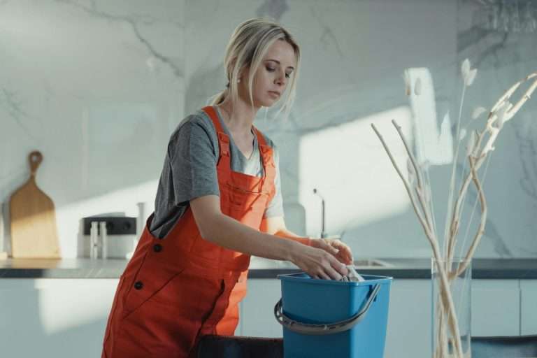 Professional cleaner in orange overalls performing move-out deep cleaning in {location}