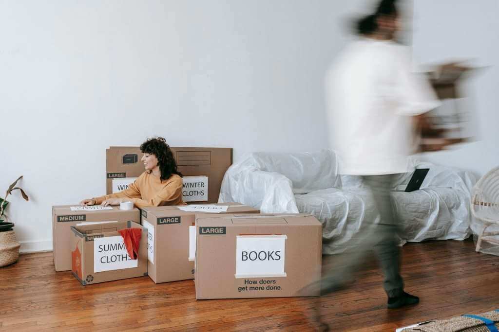 Tenants moving out with boxes, preparing the property for end-of-tenancy cleaning