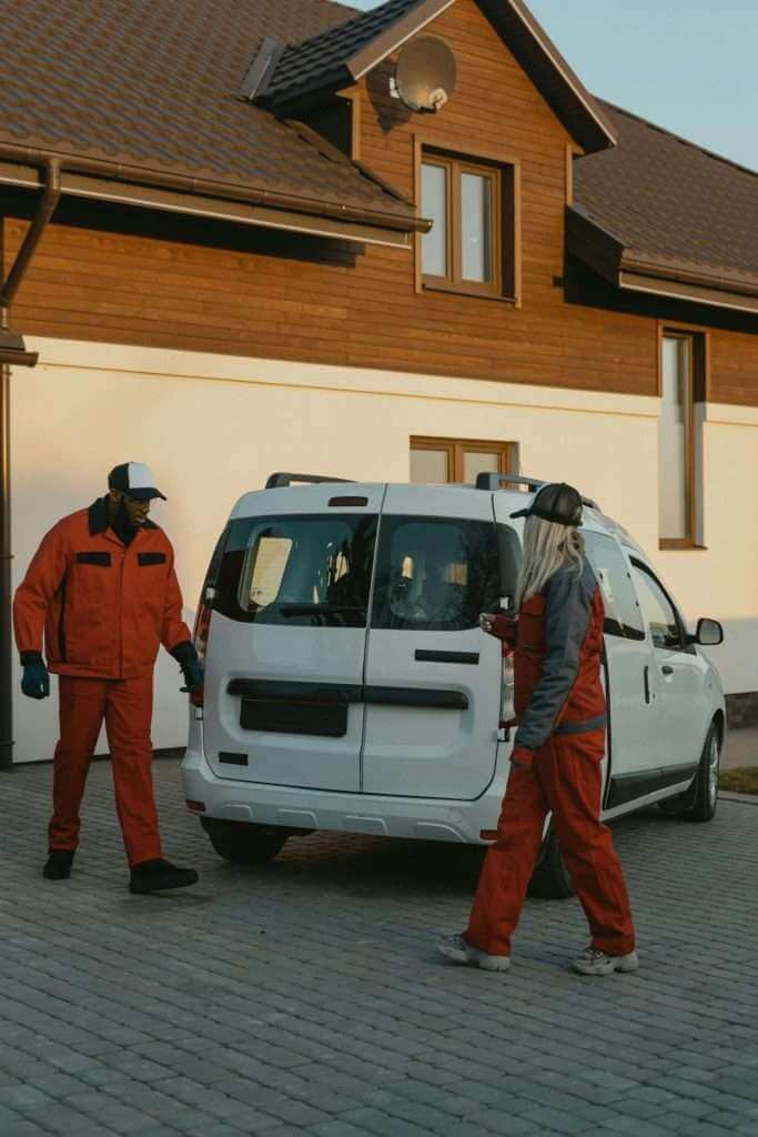 A cleaning team in uniform vacuums and cleans a room during a move-out.